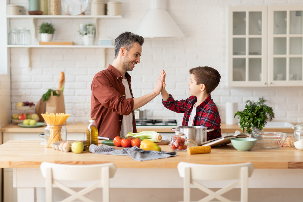 happy father give high five to loving son on home kitchen