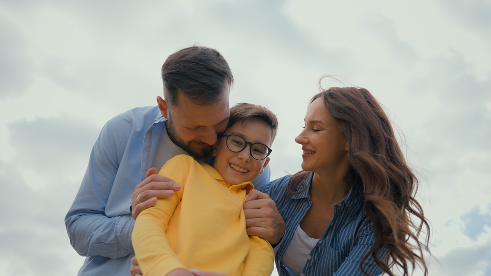 guy embracing hug cheerful adopted little boy child kid son outdoors holidays adoption