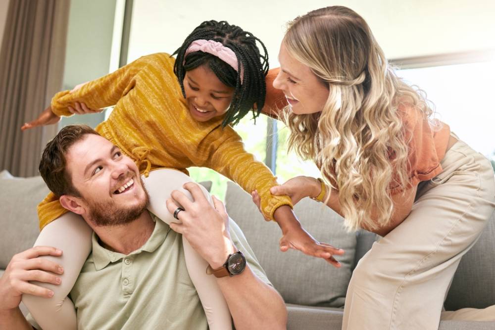 Bonding, diversity and child with parents in foster care for love, happy and safety in a family home