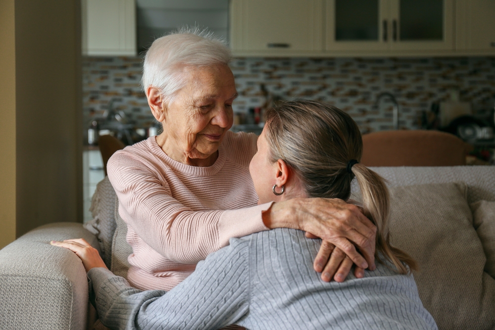 Grandmother and granddaughter hugging in the living room